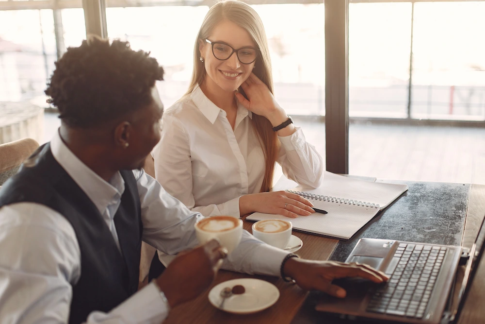 un homme et une femme collègues de travail qui boivent un café en travaillant ensemble
