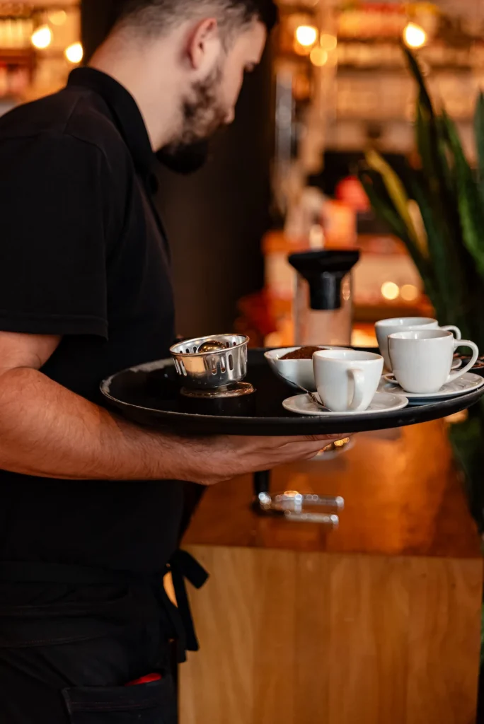 un serveur portant un plateau contenant des tasses de café